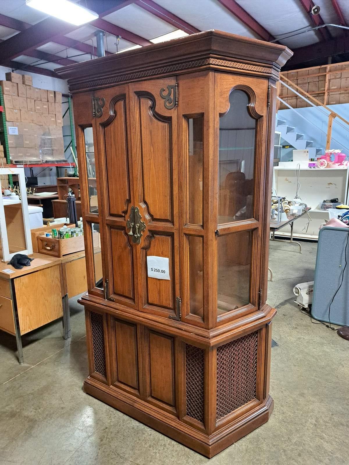 Tall vintage wooden display cabinet with glass side panels and metal hardware.
