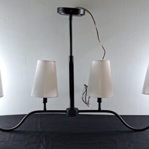 Matte black 4-light island pendant fixture with white linen shades shown out of the box on a tabletop.