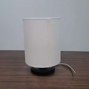 Front view of modern wall sconce with white fabric drum shade and matte black base.