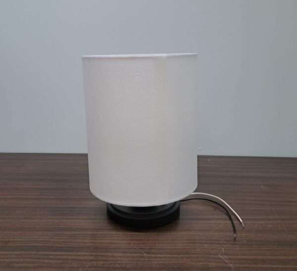 Front view of modern wall sconce with white fabric drum shade and matte black base.